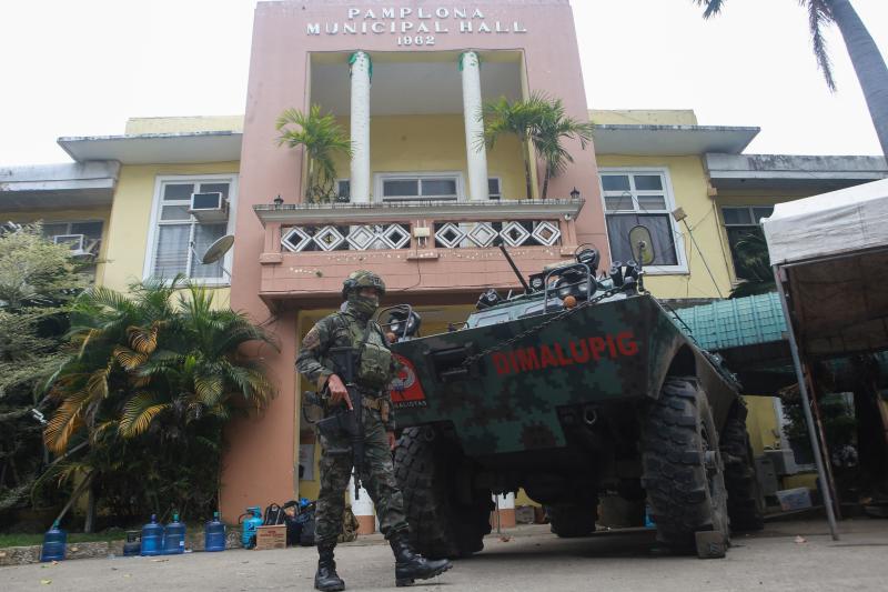 Ein bewaffnetes Mitglied der Special Action Force (SAF) der Polizei steht am 5. März 2023 vor dem Gemeindehaus in der Stadt Pamplona in Negros Oriental Wache, einen Tag nachdem der Provinzgouverneur Roel Degamo und acht weitere bei einer Massenerschießung getötet wurden. (AFP-Foto) Ein bewaffnetes Mitglied der Special Action Force (SAF) der Polizei steht am 5. März 2023 vor dem Gemeindehaus in der Stadt Pamplona in Negros Oriental Wache, einen Tag nachdem der Provinzgouverneur Roel Degamo und acht weitere bei einer Massenerschießung getötet wurden. (AFP-Foto)