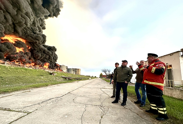 Dieses von der Regierung von Sewastopol veröffentlichte Handout-Foto zeigt Feuerwehrleute, die auf ein brennendes Tanklager in Sewastopol blicken Dieses von der Regierung von Sewastopol veröffentlichte Handout-Foto zeigt Feuerwehrleute, die auf ein brennendes Tanklager in Sewastopol blicken