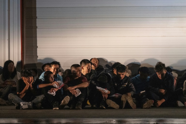 Migranten warten auf einen Bus, der sie zu einem Verarbeitungszentrum bringt, nachdem sie sich nach der Überfahrt aus Mexiko in Fronton, Texas, US-Grenzschutzbeamten übergeben haben Migranten warten auf einen Bus, der sie zu einem Verarbeitungszentrum bringt, nachdem sie sich nach der Überfahrt aus Mexiko in Fronton, Texas, US-Grenzschutzbeamten übergeben haben