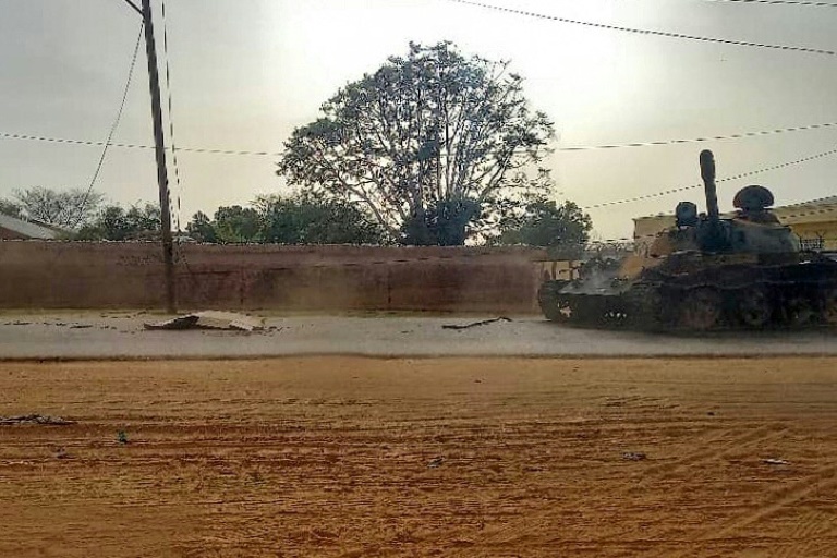Eine bedeckte Leiche liegt gegenüber einem gepanzerten Militärfahrzeug auf einer Straße in der Hauptstadt des Bundesstaates West-Darfur, El Geneina. (Foto: AFP) Eine bedeckte Leiche liegt gegenüber einem gepanzerten Militärfahrzeug auf einer Straße in der Hauptstadt des Bundesstaates West-Darfur, El Geneina. (Foto: AFP)