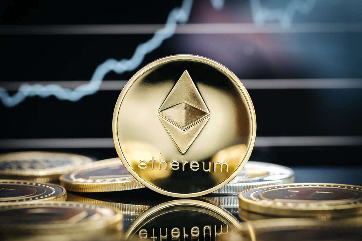 Ethereum cryptocurrency, physical coin close-up, in front of a price chart